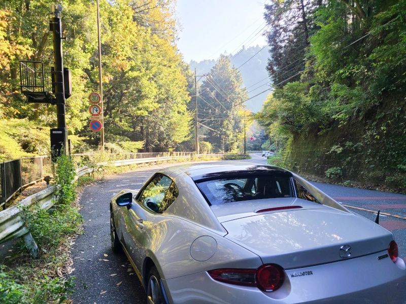 峠道を走るロードスターの写真