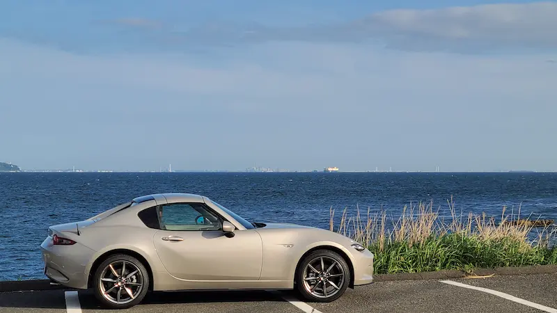 ロードスターが海辺に停車している様子