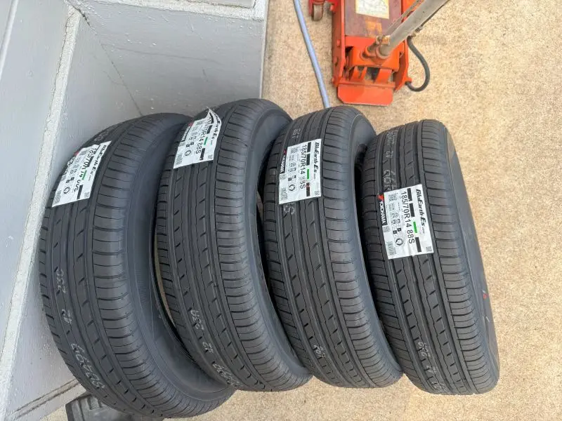 a stack of tires on a floor　タイヤ交換店舗にあらかじめ送られていた新品タイヤ
