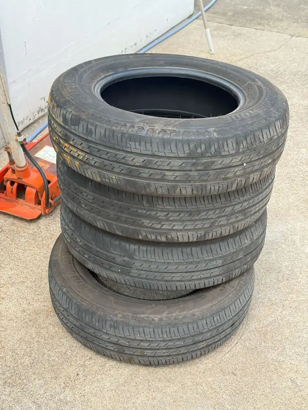 a stack of tires on a concrete surface　　今回のタイヤ交換によって廃棄されるタイヤ