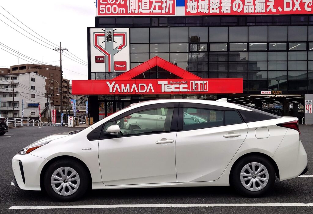 ヤマダ電機の駐車場で査定を受けるプリウス